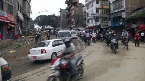 Kathmandu, Nepal - 04 11 2019: Cars and Motorcycles going round a corner on busy road in Kathmandu, Nepal