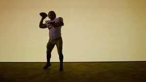 American football player posing against a huge bright screen. Shot on ARRI Alexa Mini in 4K RAW - Powered by Shutterstock - Get 15% off with code: PIKWIZARD15