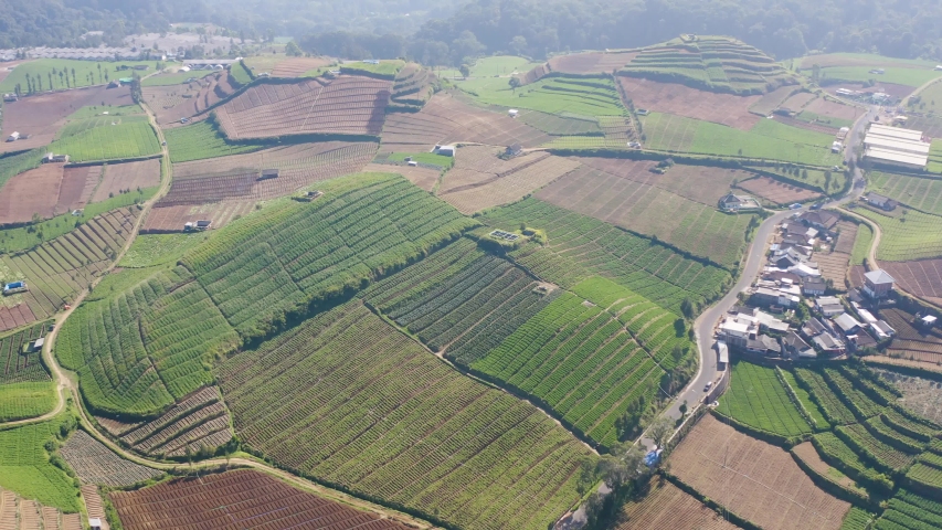 Cangar, east java - july 27, 2019.  aerial landscape view of Cangar, near Batu city.  Many plantations in this area.  it's located in Bumiaji county,   | Shutterstock HD Video #1034047595