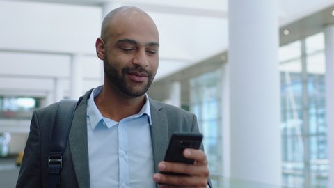 happy mixed race businessman using smartphone texting walking in corporate office typing text messages on mobile phone checking emails successful male executive at work 4k footage