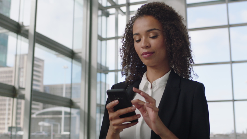 Beautiful business woman using smartphone texting walking in corporate office building checking email messages online successful female executive at work 4k | Shutterstock HD Video #1034051471