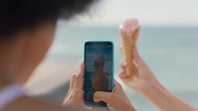 young woman holding ice cream on beach with friend taking photo using smartphone sharing delicious dessert on social media 4k - Powered by Shutterstock - Get 15% off with code: PIKWIZARD15