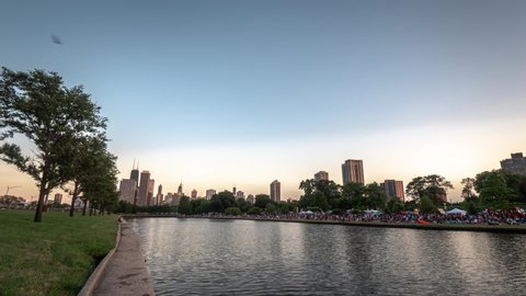 Chicago, IL - July 20th, 2019: Crowds begin to gather for Chicago's first water lantern festival on the south lagoon in Lincoln Park on Saturday with the beautiful backdrop of the city skyline.