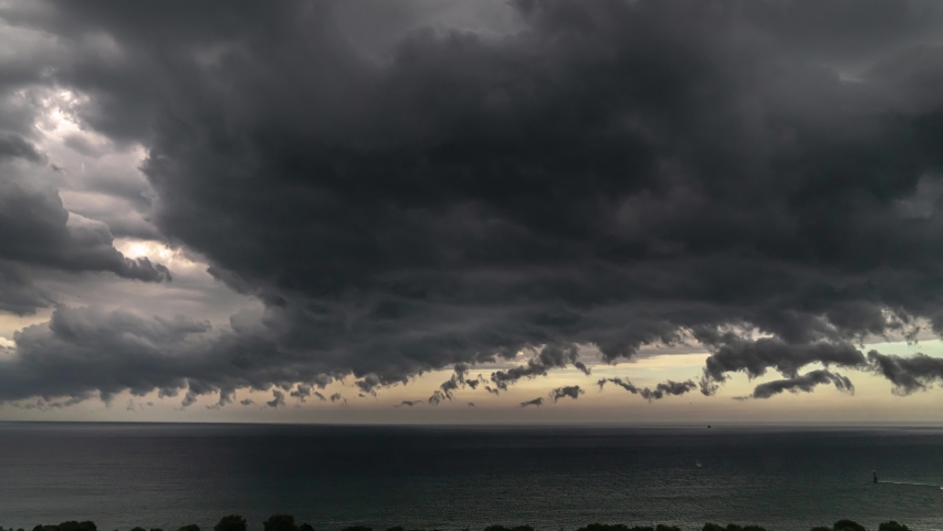 Aerial view of dramatic dark storm clouds as they roll and tumble past each other as they form and dissolve over the Lake in Chicago as rainy weather and lightning comes into the area.