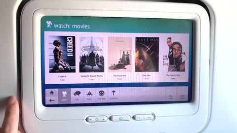 Los Angeles, CA / United States - 04 11 2019: Hand scrolling through in flight entertainment on an Alaska Airlines flight.