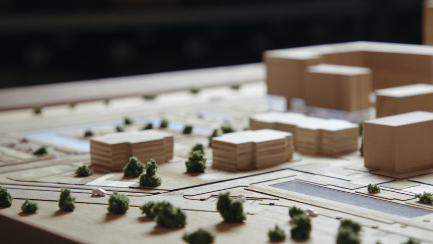 Craftsman Arranges Buildings on a Wooden Architectural Layout. Woodworker Made a Toy Miniature and Plans where to Put the Figure. Caucasian Man Focused Addicting Hobby Close-up Shot Royalty-Free Stock Footage #1034055215