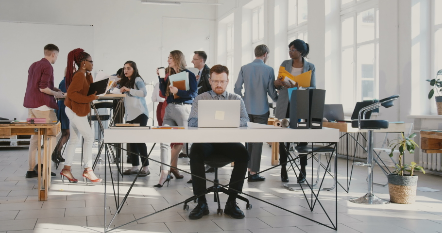 Camera zooms in on exhausted young businessman throwing paper documents in the air at busy modern office table RED EPIC. Royalty-Free Stock Footage #1034056733