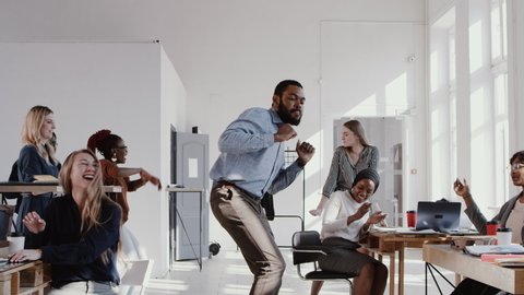RED EPIC Happy fun young black boss businessman doing epic dance at office celebrating success with team slow motion. : vidéo de stock