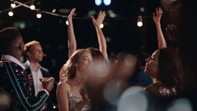 happy group of friends celebrating new years eve party dancing throwing confetti enjoying glamorous celebration wearing stylish fashion social gathering on rooftop at night 4k - Powered by Shutterstock - Get 15% off with code: PIKWIZARD15