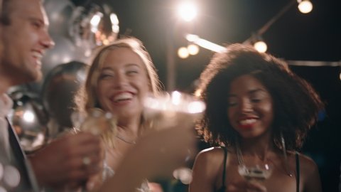 group of stylish friends celebrating at glamorous rooftop party event making toast drinking champagne at formal social gathering enjoying evening celebration at night 4k