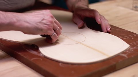 Luthier insert the rosette into the guitar body