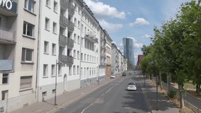 Flying through the streets of Frankfurt. Driving along an empty street in downtown and zoom in on tall building.