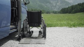 4k resolution video of electric lift specialized vehicle for people with disabilities. Empty wheelchair on a ramp with nature and mountains in the back. Self help for disabled people concept