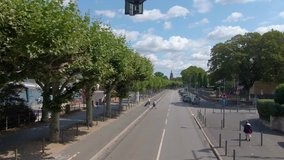 Flying through the streets of Frankfurt. Driving along downtown on an empty street with trees beside the river Main.
