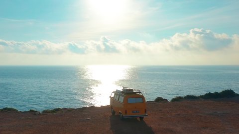 California, United States, JULY 20TH, 2019: Aerial view. Yellow VW bus van on a parking lot on a rock near the sea.