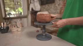 An approaching camera shot of a young female professional potter molding ceramic pot on rotating stand. Traditional carving concept. Terracotta ceramic product - Powered by Shutterstock - Get 15% off with code: PIKWIZARD15