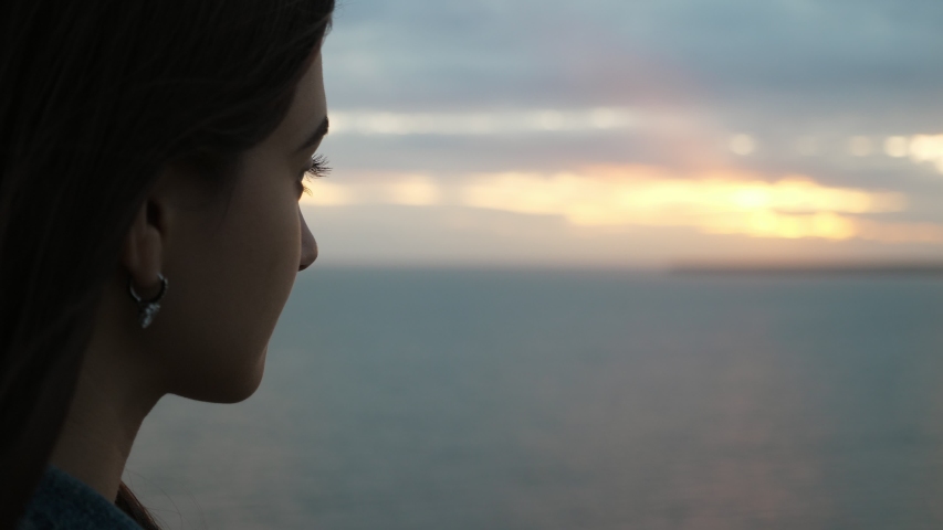  Incredible profile of a tender young brunette girl looking and enjoying the view of the picturesque  Black Sea waves at sparkling sunset in summer in slo-mo   | Shutterstock HD Video #1034083394