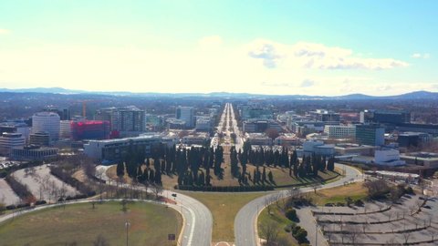 Aerial view rising up over Canberra City looking north over Parkes Way, City Hill and Northbourne Avenue in the distance  