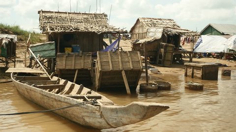 Small fishermen's stilt-houses with dugout canoe, fish crates and hen houses on the edge of the river