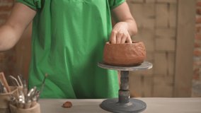 A close-up of female potter carefully shaping ceramic pot. Terracotta color ceramics. Artist working in studio. Hobby and profession concept - Powered by Shutterstock - Get 15% off with code: PIKWIZARD15