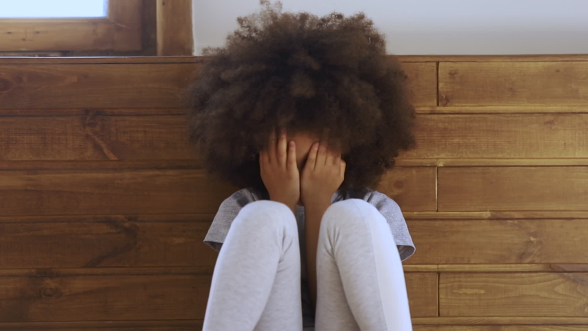 Upset little african american preschool kid girl crying alone feeling bullied abused abandoned, sad offended lonely black child stressed or scared sitting on floor, children problems concept | Shutterstock HD Video #1034099168