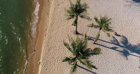 Aerial view of young  beautiful woman swing at tropical sandy beach   on Phu Quoc island, Phu Quoc. Romantic beach sunset with calm sea and girl on swing.Travel beach concept.