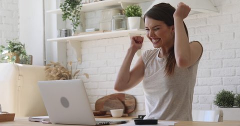Overjoyed girl student celebrate online win success read great news using laptop feel amazed sit at home, happy excited woman looking at computer surprised got good test exam result scholarship