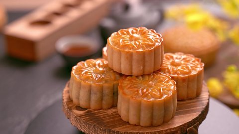 Woman taking beautiful moon cake pastry to eat and share with family to celebrate Mid-Autumn Festival. Reunion event concept.
