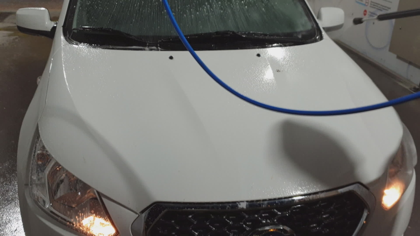 car Express car wash self-service, man washes his car at night