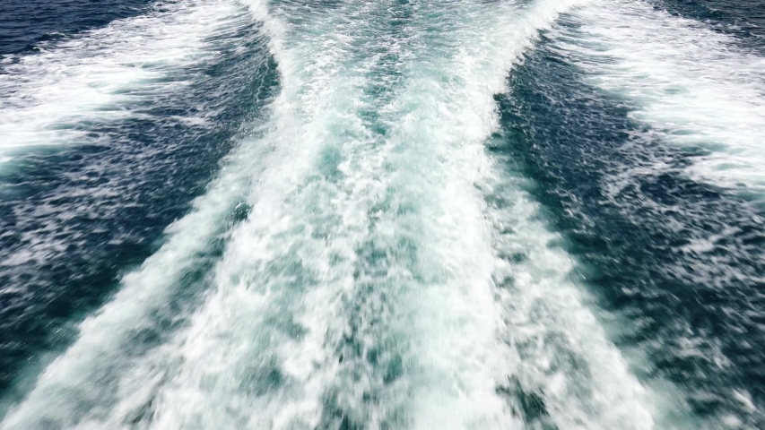 Waves of the sea foam and shallow ripples near the ship.