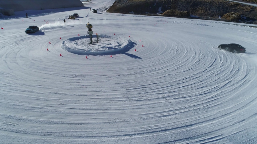 Vehicle Testing Circular Field With Winter Snow Conditions. Cars Testing Tyres Tires Wheels and Engine Performance on Cold Weather. Drone Aerial