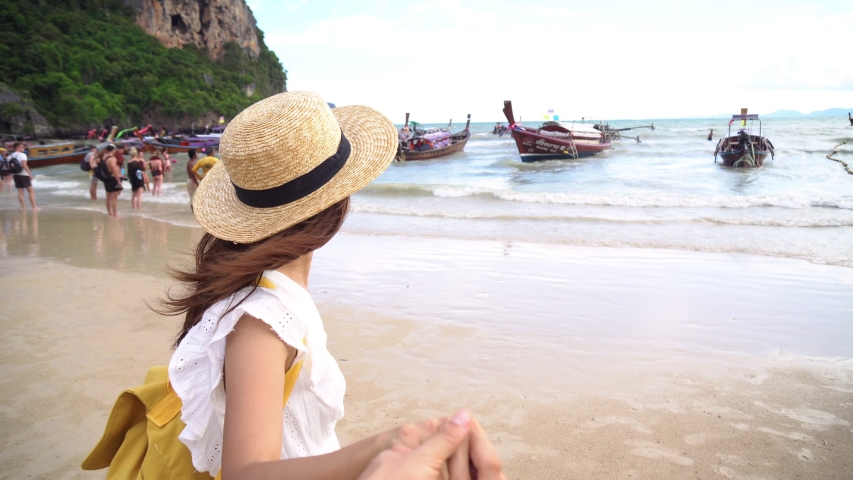 Young couple traveler enjoying a summer vacation at tropical sand beach in Krabi, Thailand