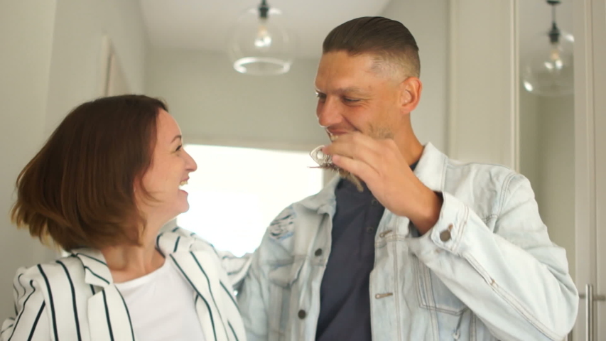Wife and husband cheer when buying a new home. Couple with keys in their hands laughs and hugs