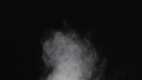 Slow motion of water vapor comes from below over black background