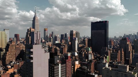 NEW YORK - JULY 24, 2019: Midtown Manhattan skyscrapers from aerial view moving over buildings toward Empire State Building in New York City NYC.