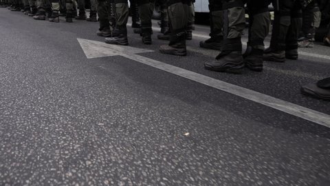 A detachment of soldiers built in one line. Special police unit in anticipation of the order of the commander. Soldiers in green camouflage, body armor and black boots. The military defend the borders