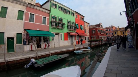 Venice, Italy - December - 14, 2018: 4K. Ultra HD. First person sight touring the streets of Burano. Under the afternoon light and colorful houses of the village. Holidays.