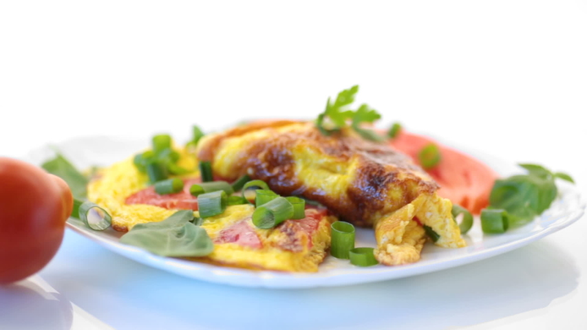 fried omelet from homemade organic eggs with tomatoes and green onions