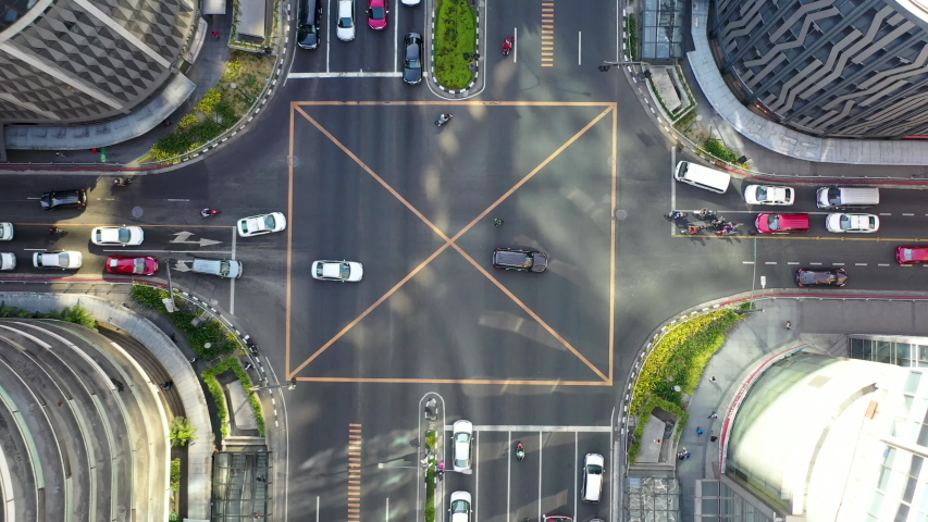 4K aerial cinematic footage of city metropolitan road intersection with cars and motorcycles crossing and turning in between skyscrapers in business district Philippines Makati Manila Royalty-Free Stock Footage #1034129423