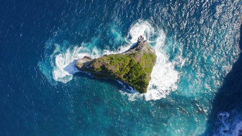 Spinning Zoom Out Drone Shot of Nusa Banah Island at Nusa Penida, Bali - Indonesia. Small Triangle Shape Island