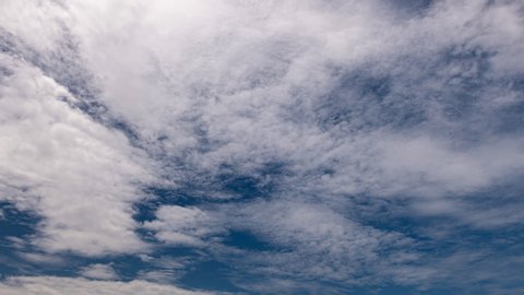 Timelapse of white clouds with blue sky in background