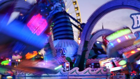 Düsseldorf, Germany - JULY 2019: Night blur illuminating atmosphere at "Octopus amusement ride" with speedy, spinning, swinging and rotating movement, at Rheinkirmes. Night amusement park with sound.