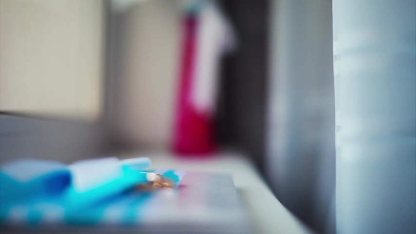 the concept of advertising jewelry, wedding events - two gold rings on a bow of blue ribbon and white sheet