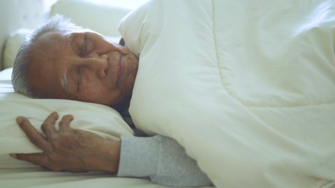Old man sleeping alone at the morning on the bed in bedroom. Shot in 4k resolution