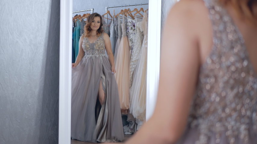 Beautifu bride choosing wedding dress in a wedding salon