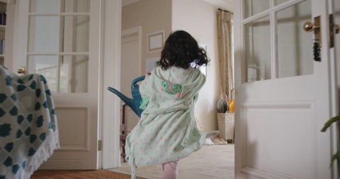 naughty children running through house cute little girl smiling chasing her brother with watering can excited kids enjoying childhood game having fun on weekend morning wearing pajamas 4k