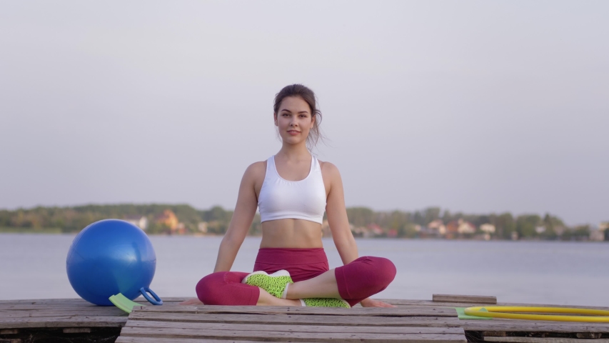spiritual world, young lovely yogi woman in lotus position meditates and delight spiritual calmnes on open air near water