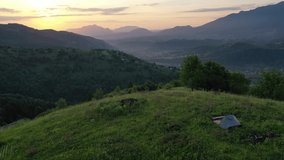Drone video with two mountain bicycles and a tent on a mountain meadow in beautiful sunrise light