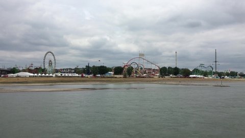 DUSSELDORF, GERMANY - JULY 14, 2019: Wide Shot of large Fun Fair "Rheinkirmes" with Ferris Wheel, Roller Coaster and Carnival Rides