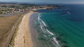 ocean waves sandy beach with people bathing in the water view from drone Lanzada beach Galicia Spain 4k video